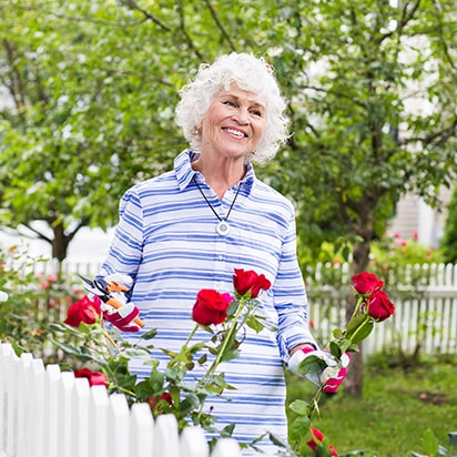 Woman cutting roses wearing HomeSafe help button