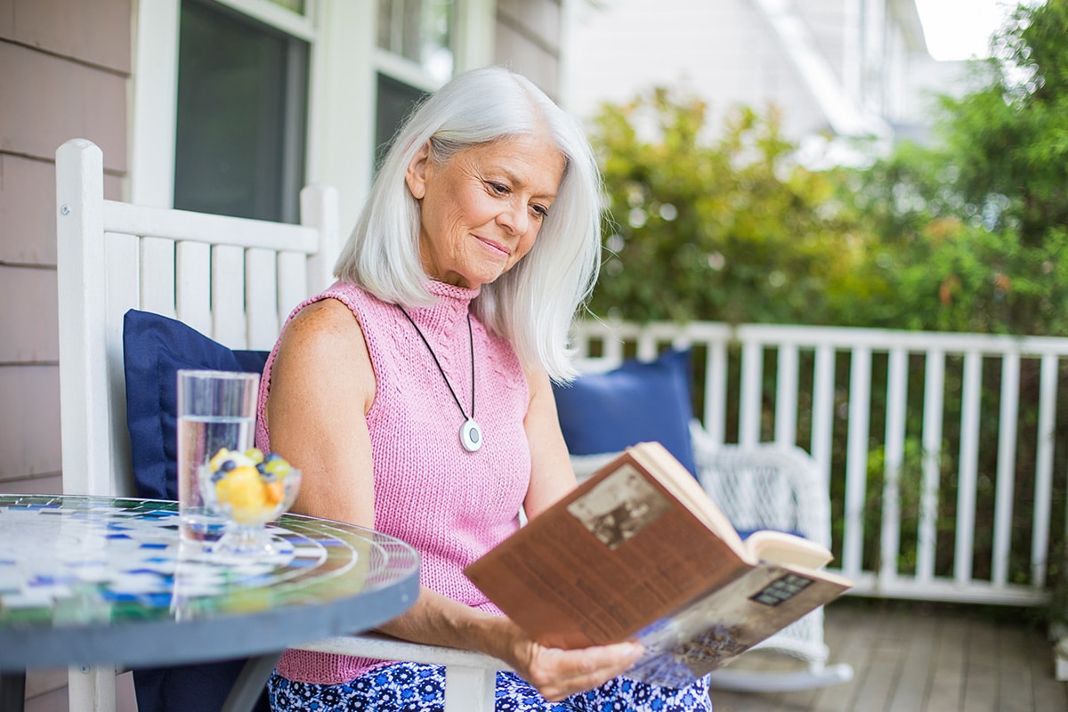 Woman reading book wearing HomeSafe help button